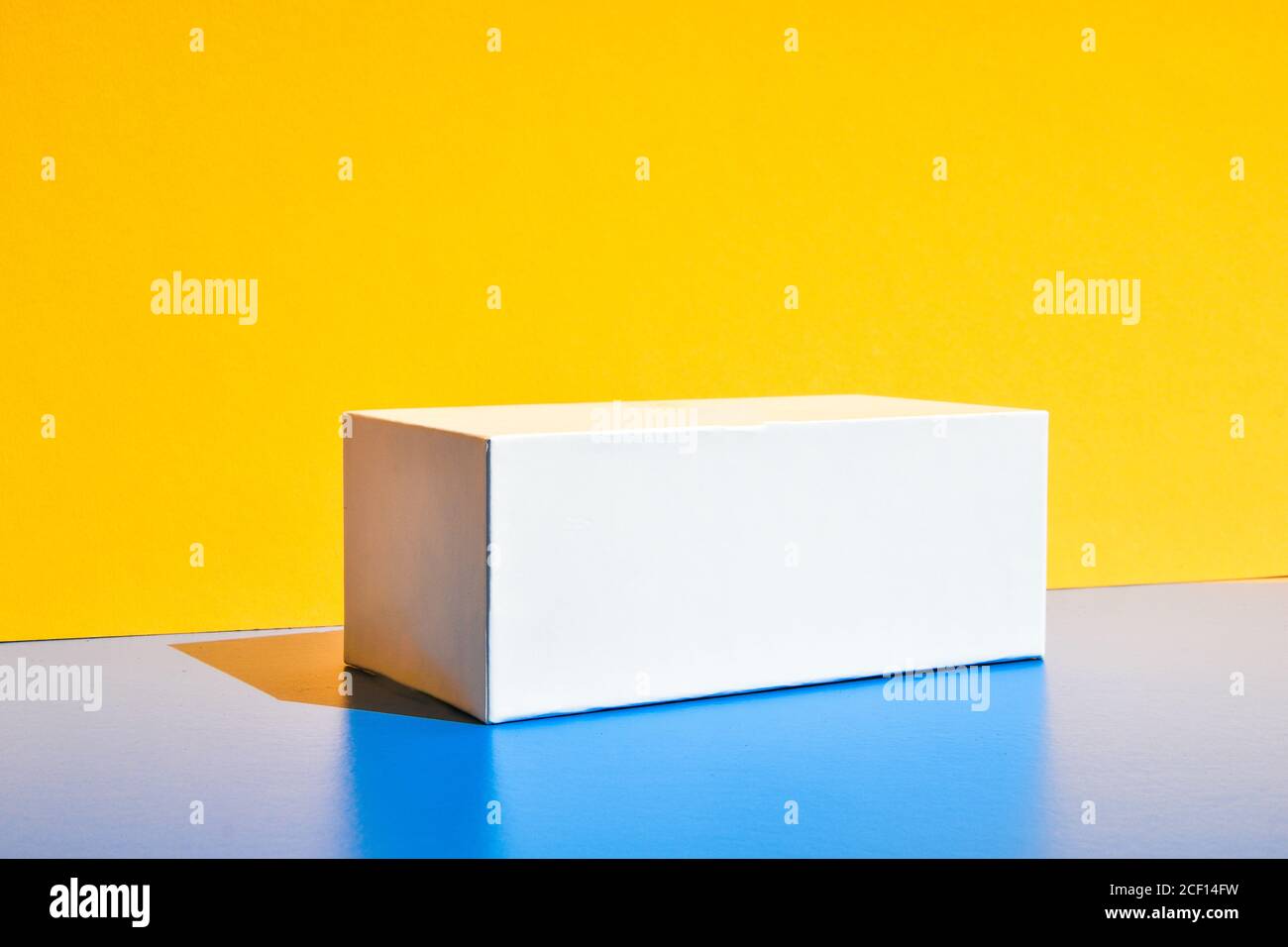 Weißes Feld. Modell der Drogenbox. Modell. Speicherplatz kopieren. Gelb und blau kreativen Minimalismus isometrischen Hintergrund Stockfoto