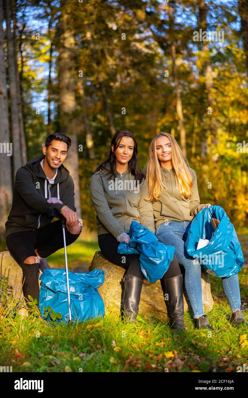 Weibliche Freiwillige sammeln Müll auf Gras Stockfoto