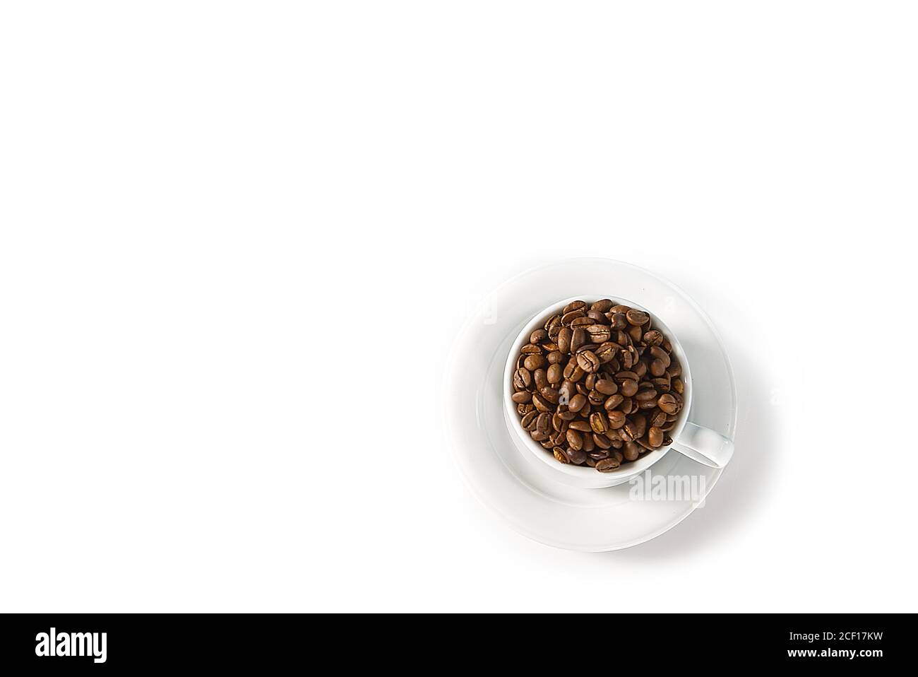 Kaffeebohnen in weißer Tasse, Nahaufnahme. Weiße Kaffeetasse mit Kaffeesamen auf weißem Hintergrund. Konzept für den Internationalen Tag des Kaffees. Stockfoto