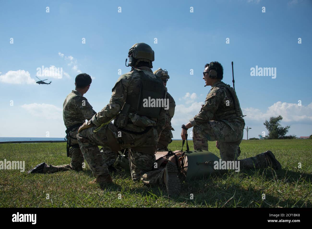 TORII STATION, Japan – Grüne Berets mit 1. Bataillon, 1. Spezialeinheit (Airborne), warten auf einen Hubschrauber, um während des medizinischen Evakuierungstrainings am 19. August 2020 einen simulierten Unfallopfer in die Torii Station, Präfektur Okinawa, Japan, zu laden. Soldaten der Spezialeinheiten führen häufig MEDEVAC-Schulungen durch, um sicherzustellen, dass sie bereit sind, Verwundete im Falle von realen Einsatzszenarien schnell in nachfolgende medizinische Einrichtungen zu transportieren. (USA Armee Foto von Sgt. Anthony Bryant) (Dieses Bild wurde zu Sicherheitszwecken geändert, indem identifizierbare Abzeichen verschwommen wurden.) Stockfoto