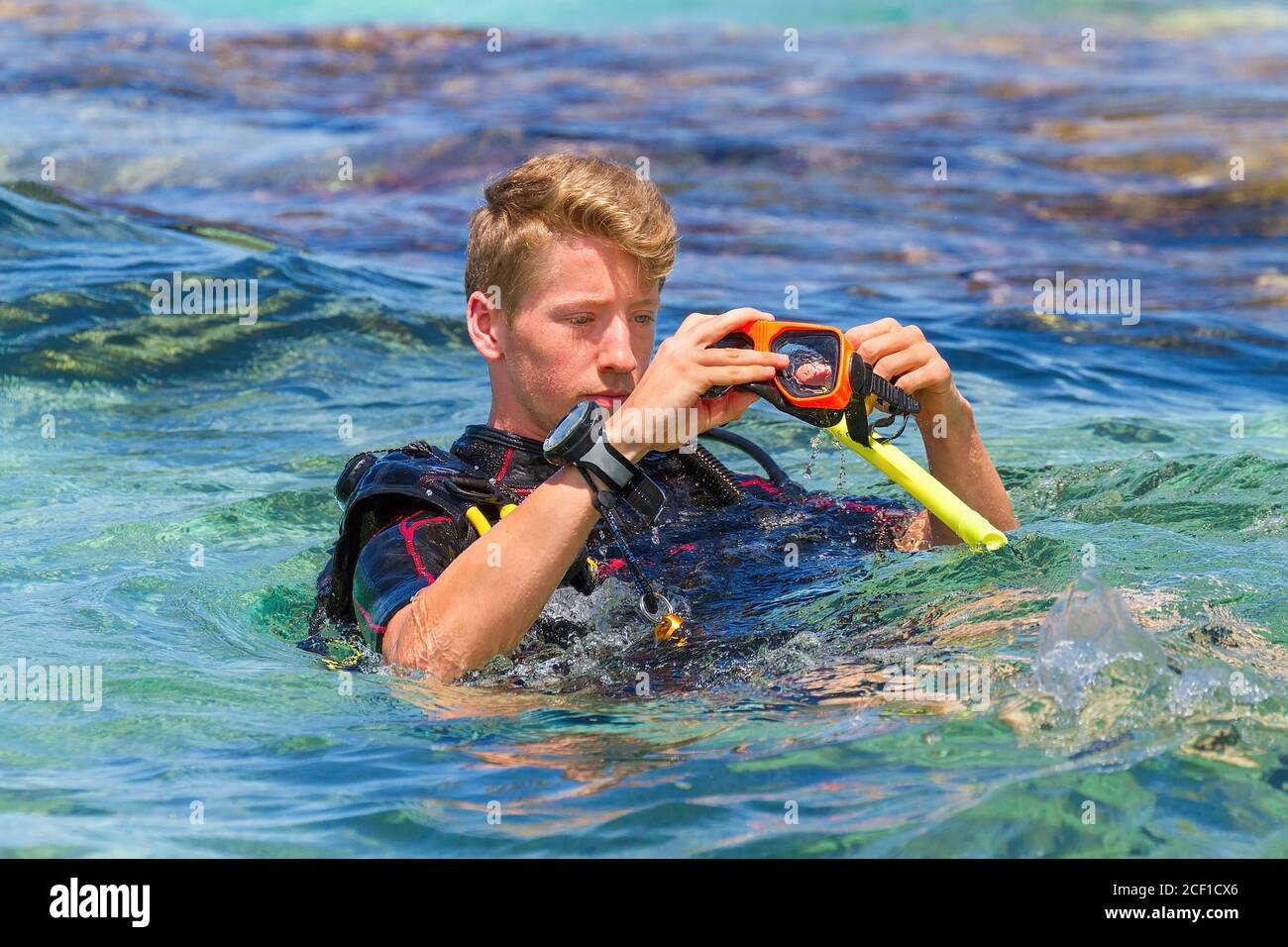Junge kaukasische Mann als Taucher im Meer Vorbereitung Tauchmaske Stockfoto