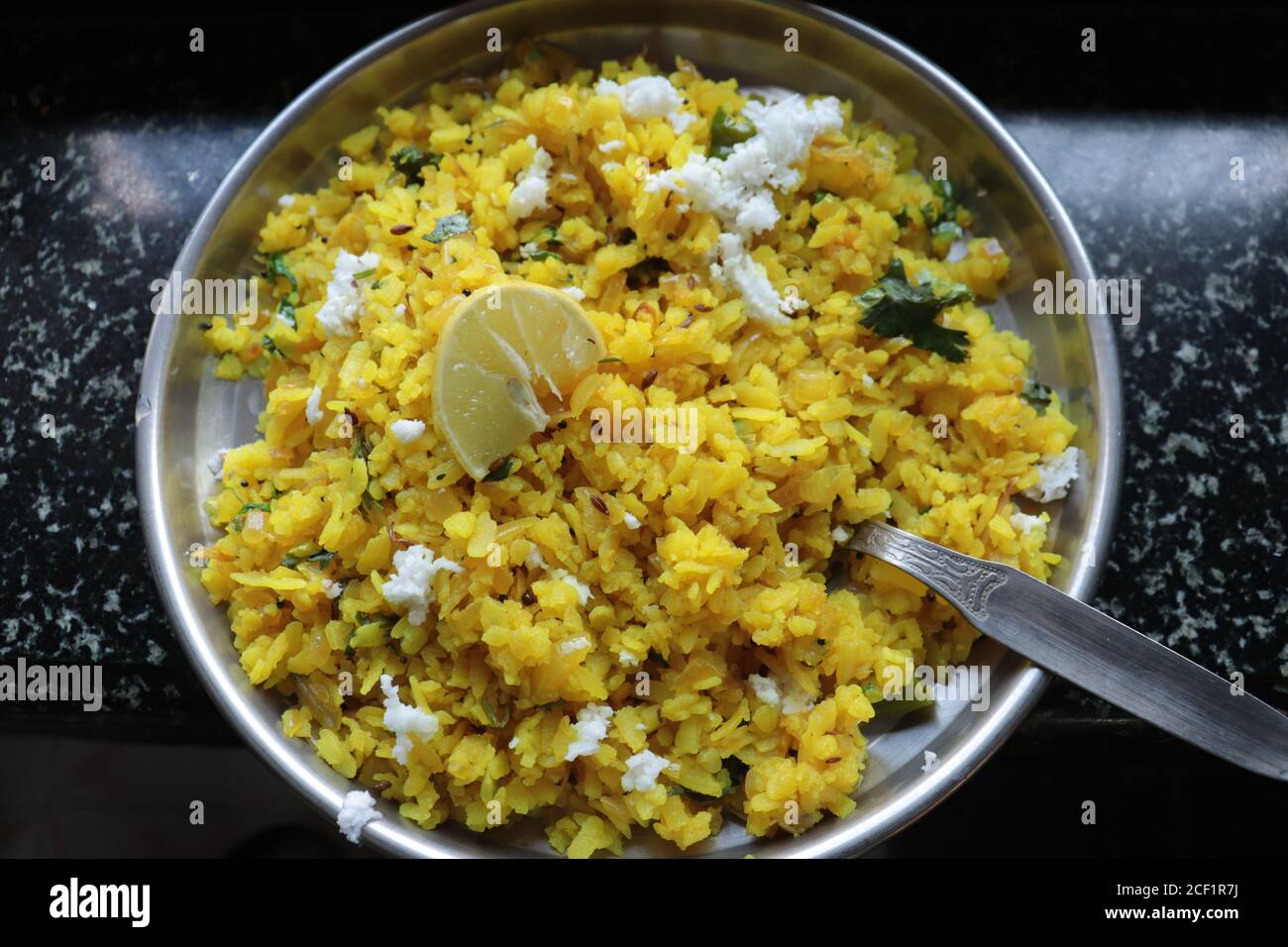 Kanda Poha beliebte Maharashtrian Frühstück Rezept aus roten oder weißen abgeflachten Reis, Kartoffeln, Zwiebeln, Kräuter und Gewürze Stockfoto