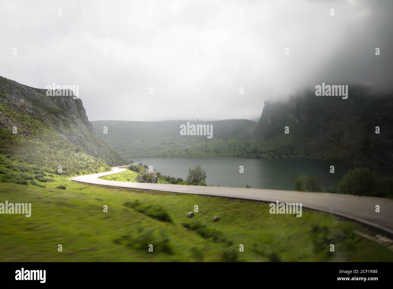 Fotografie in Bewegung. Blick auf eine abgelegene Autobahn vom Auto aus. Fahren Sie in einer bergigen Umgebung mit Seen. Stockfoto