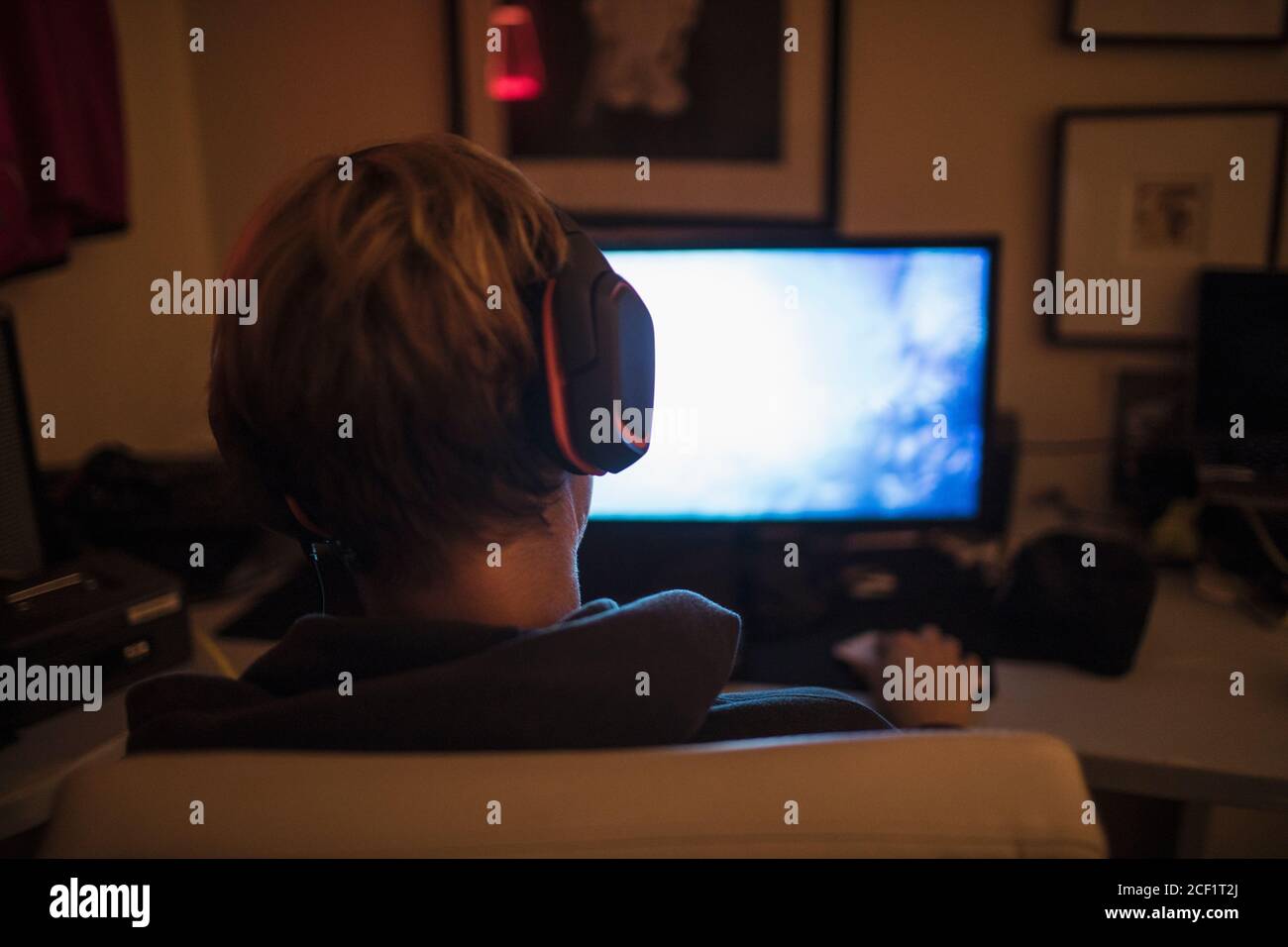 Teenager Junge mit Kopfhörer spielen Videospiel im dunklen Schlafzimmer Stockfoto