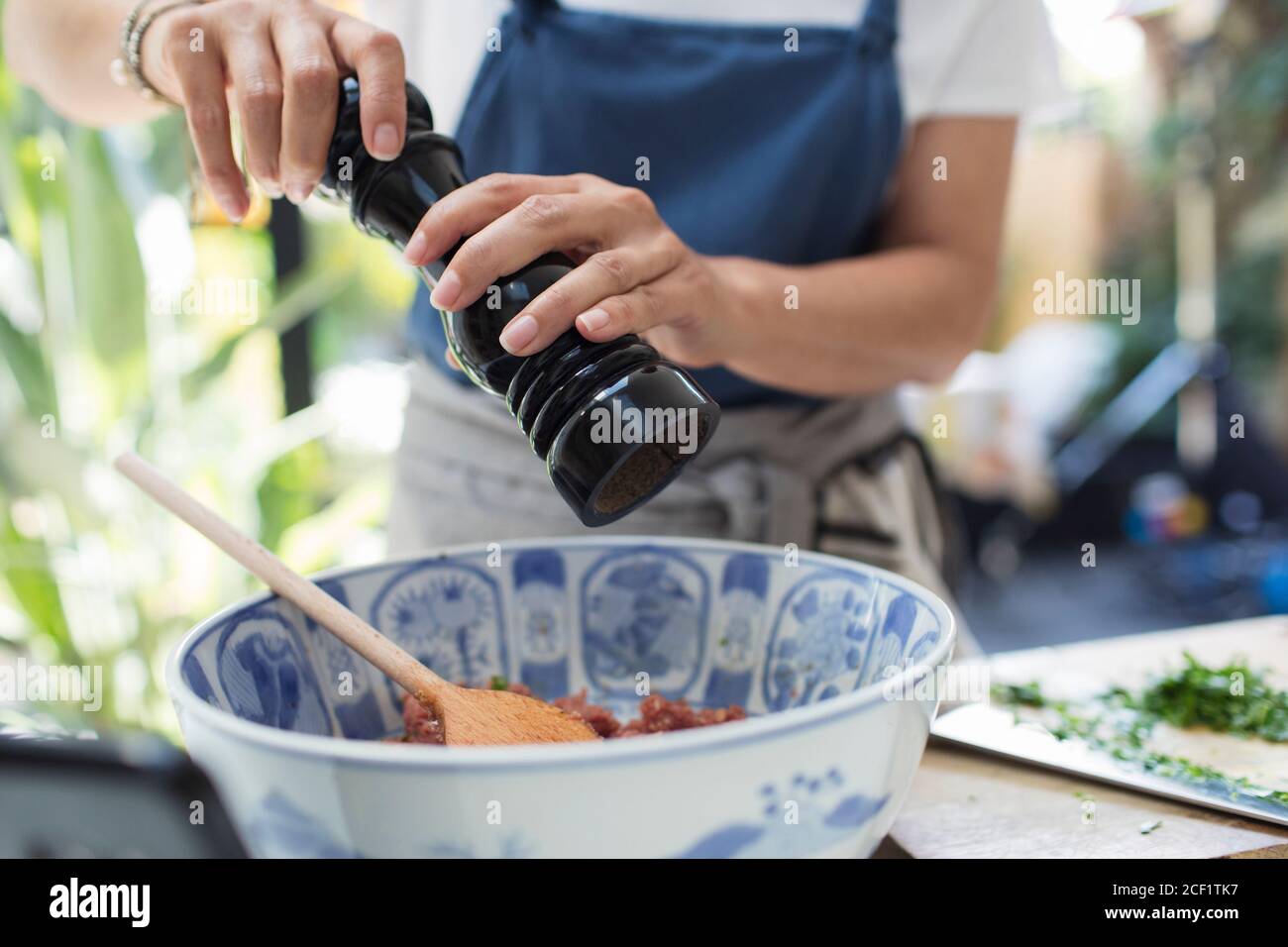 Nahaufnahme Frau mit Pfeffermühle Kochen in der Küche Stockfoto