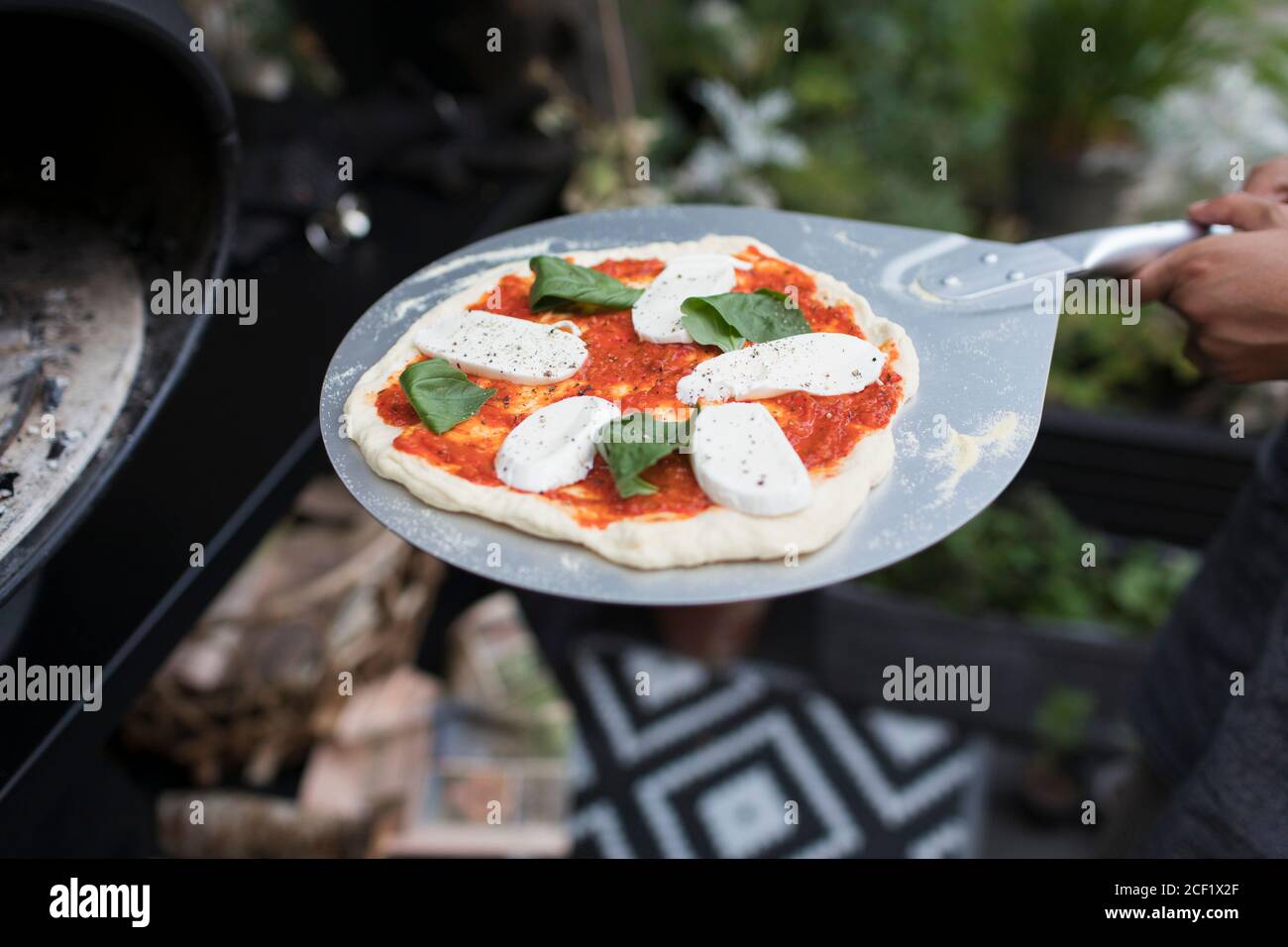 Frische hausgemachte Pizza auf Pizzaschalen im Ofen Stockfoto