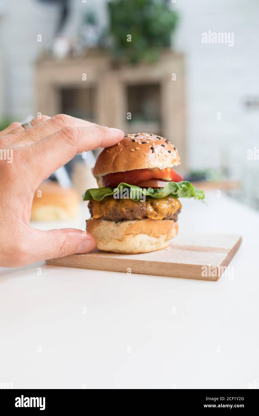 Hand greifen für Cheeseburger Schieberegler Stockfoto