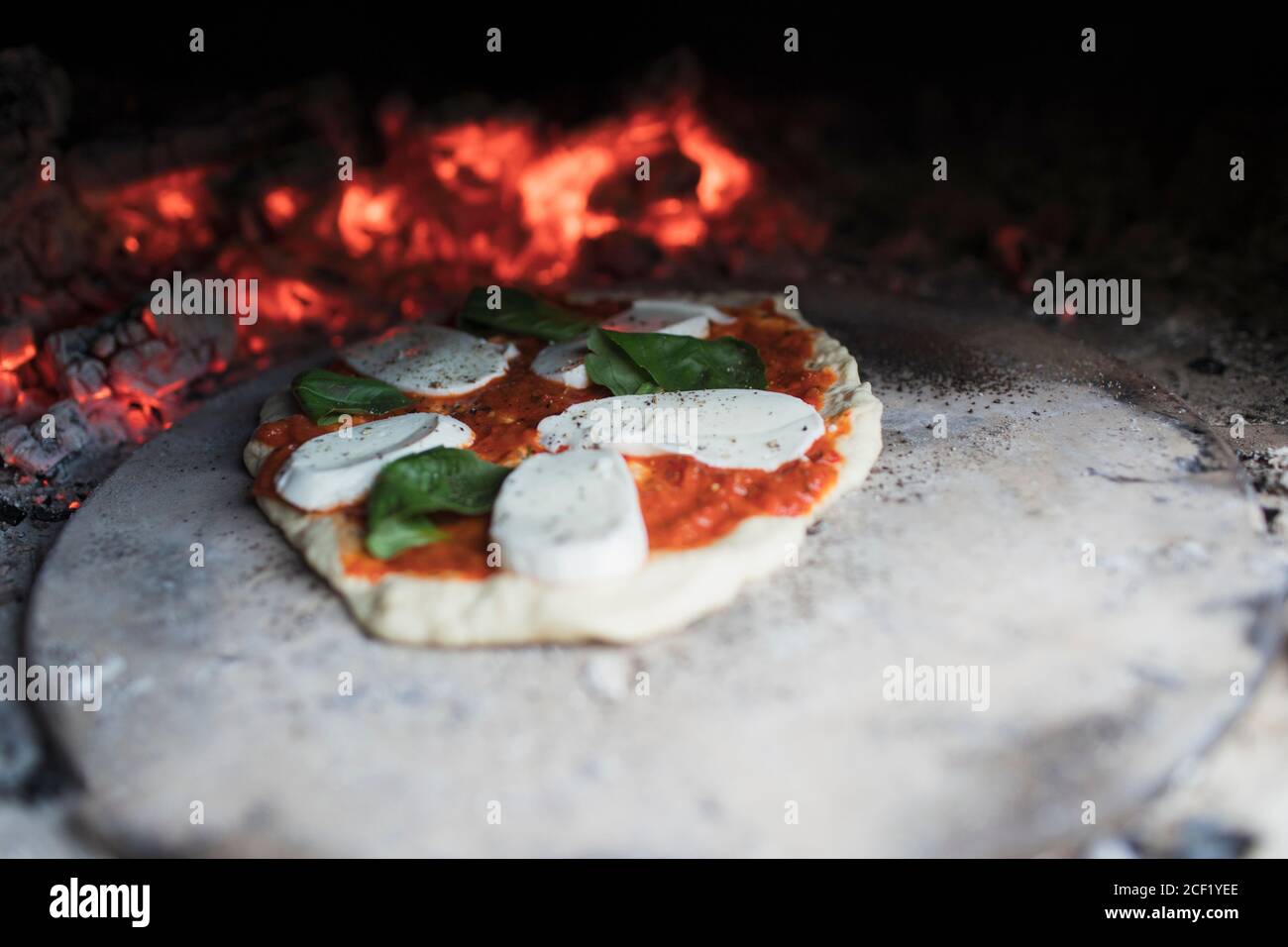 Hausgemachte margherita Pizza auf Stein im heißen Pizzaofen Stockfoto