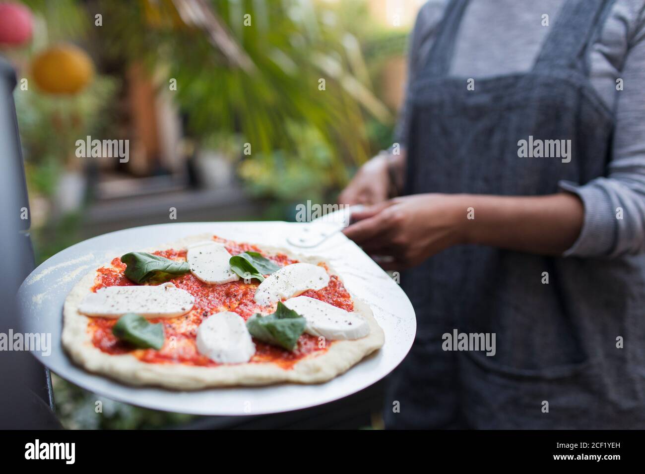Frau mit frisch hausgemachter margherita Pizza auf Schale Stockfoto