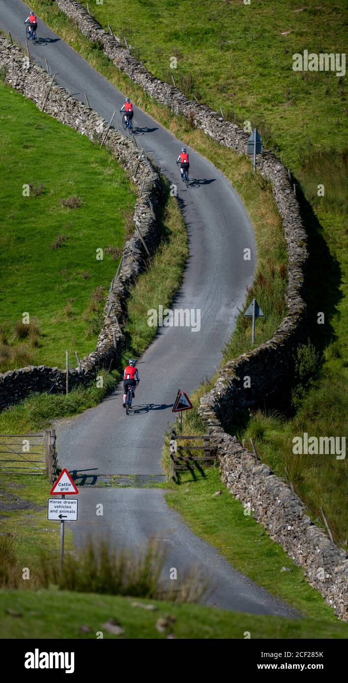 Mehrere Bilder von Radfahrerinnen, die auf ihrem Elektrofahrrad einen steilen Hügel im Yorkshire Dales Nationalpark, Großbritannien, erklimmen. Stockfoto