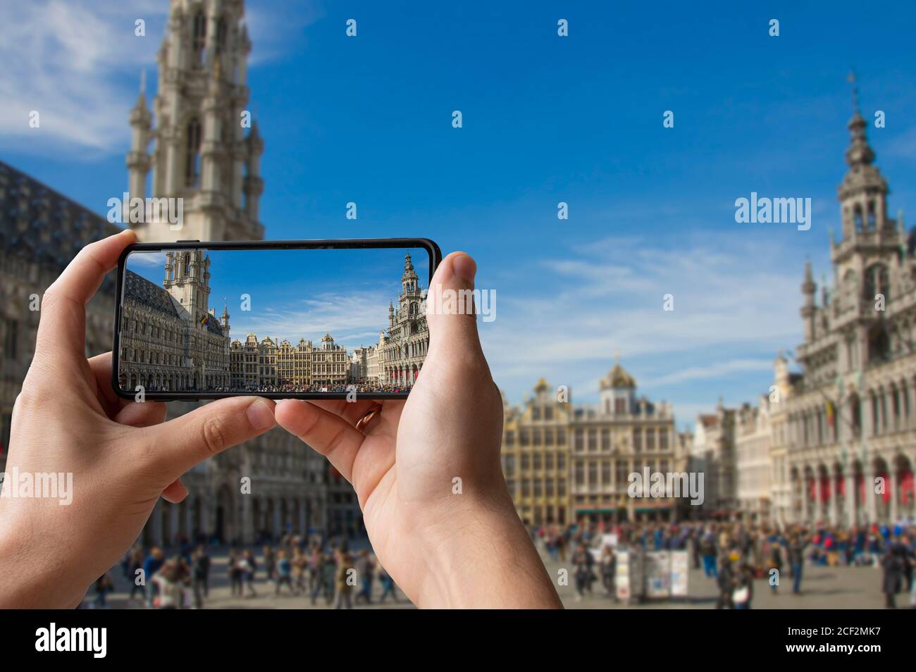 Tourist fotografiert den Grand Place (Grote Markt) in Brüssel, Belgien. Mann, der Telefon hält und fotografiert. Stockfoto