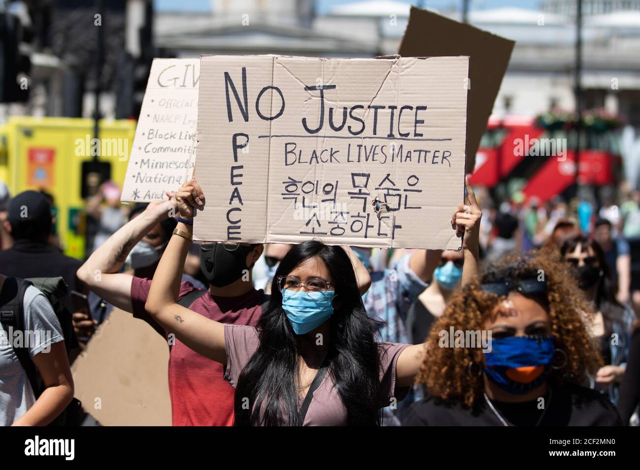 Eine asiatische Frau hält ein No Justice No Peace Zeichen bei einem Black Lives Matter Protest auf dem Trafalgar Square in London Stockfoto