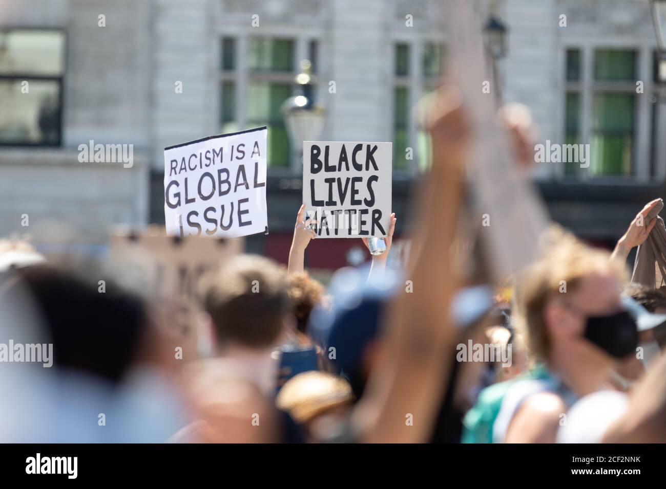 Ein Paar Black Lives Matter-Zeichen, eines, das bei einem Protest auf dem Trafalgar Square in London sagt: "Rassismus ist ein globales Thema" Stockfoto