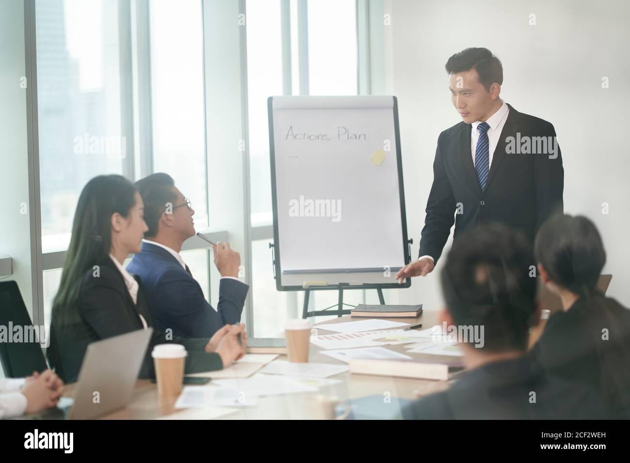 asiatische Unternehmensleitung präsentiert Aktionspläne in Geschäftstreffen in Konferenzraum Stockfoto