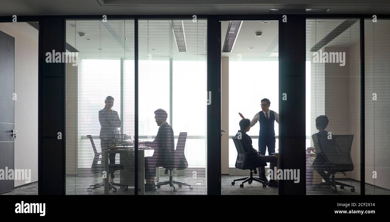 Panoramablick auf geschäftige asiatische Geschäftsleute, die Meetings abhalten Diskussion im modernen Büro Stockfoto