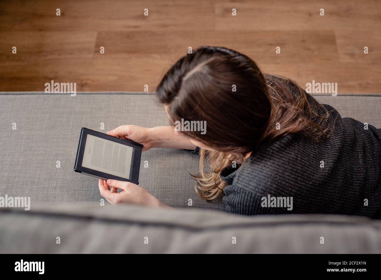 Junge Frau liest mit E-Reader Stockfoto