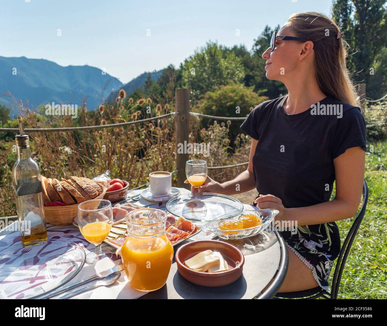 Komplettes Frühstück in den Bergen mit jungen Mädchen genießen die Mornin Stockfoto