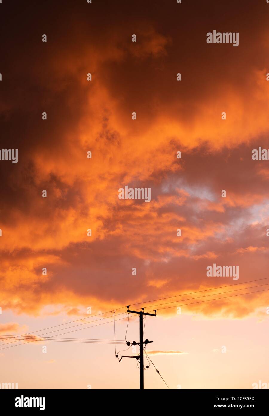 Hölzerne Stromverteilerstange und Kabel bei Sonnenuntergang, mit großer Ausdehnung des Himmels. Aufrecht. England. VEREINIGTES KÖNIGREICH Stockfoto