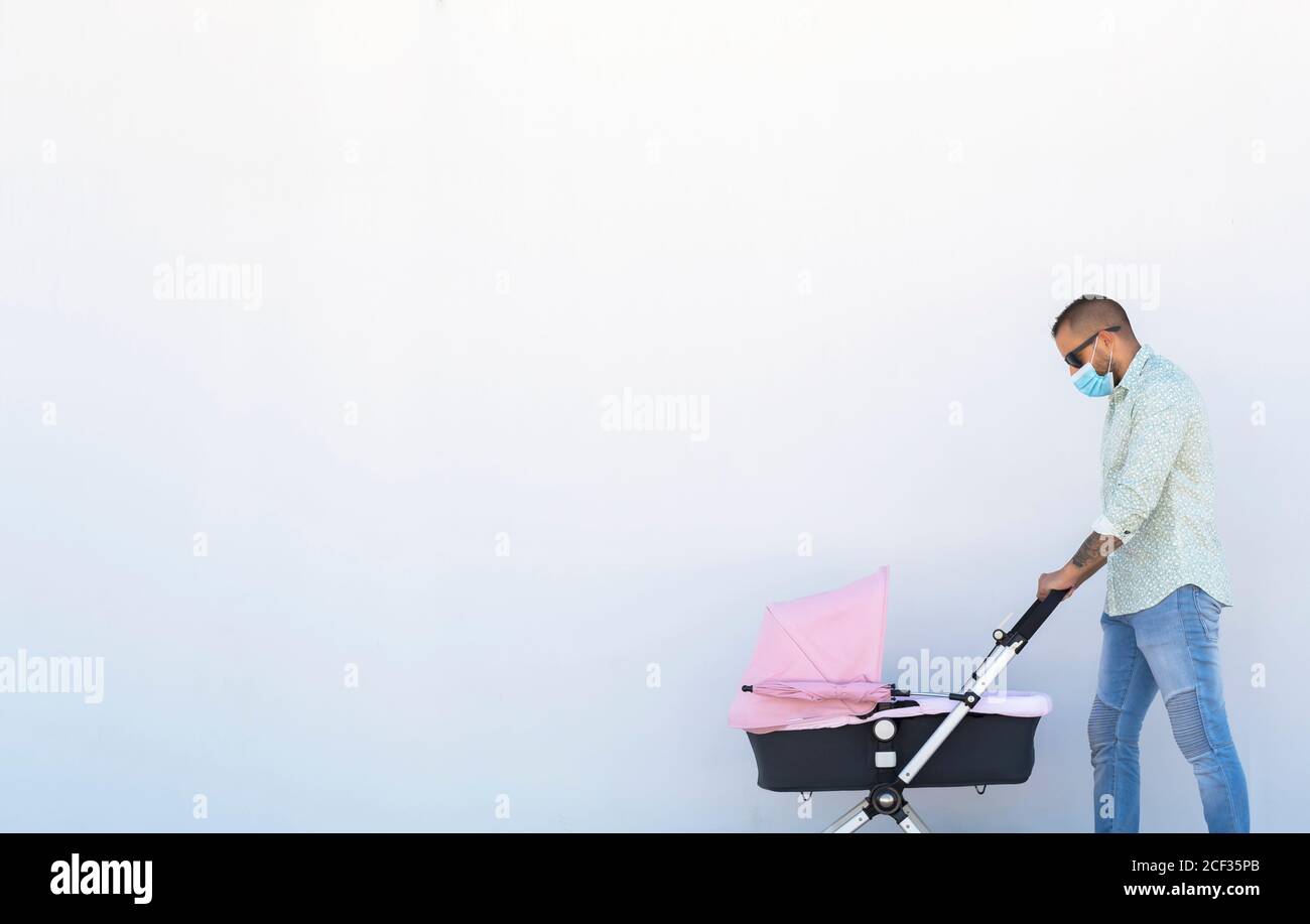 Vater geht mit dem Kinderwagen seines Babys Stockfoto