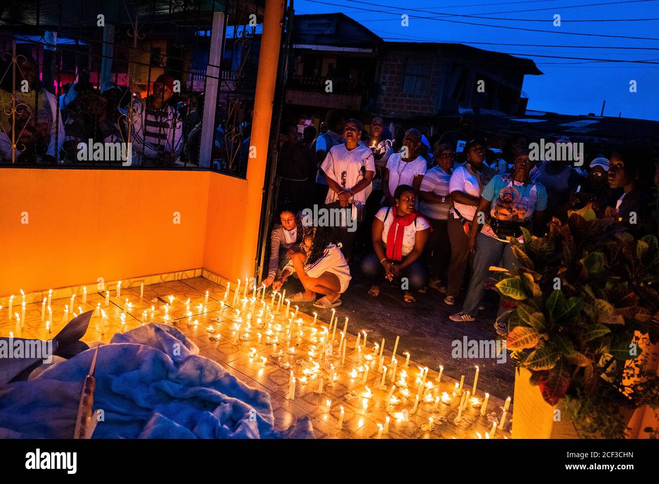 Afro-kolumbianische katholische Anhänger zünden Kerzen an, während sie an einer religiösen Prozession während des San Pacho Festivals in Quibdó, Kolumbien, teilnehmen. Stockfoto