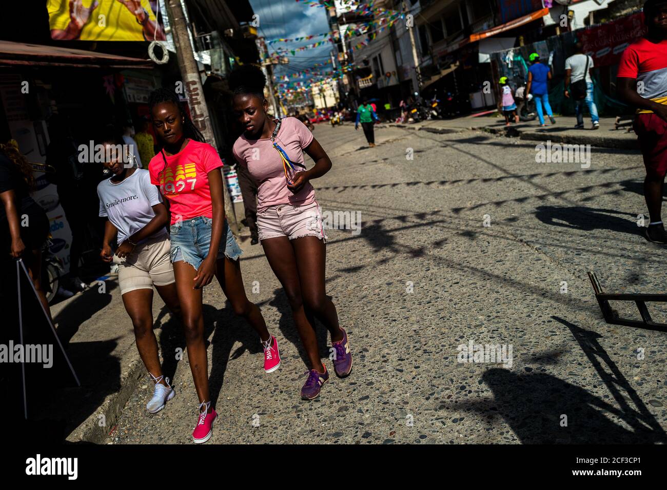 Afro-kolumbianische Mädchen gehen auf der Straße während des San Pacho Festivals in Quibdó, Kolumbien. Stockfoto