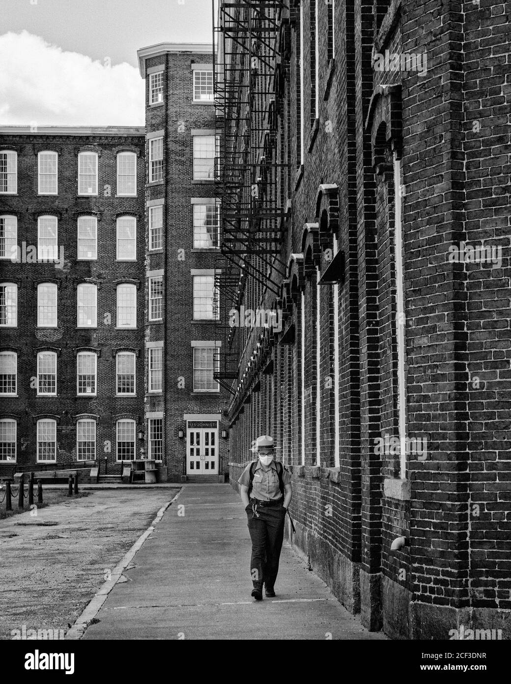 Ein Parkranger geht am äußeren Rand des Boot Mill Museums im Lowell National Historic Park in Massachusetts entlang. Im Rahmen des COVID-19-Mandats Stockfoto