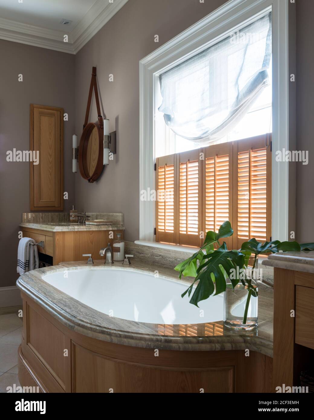 Rustikales Badezimmer mit Fensterläden über der Badewanne Stockfoto