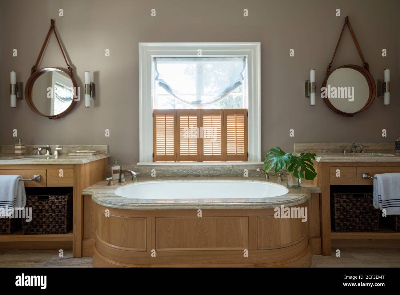 Rustikales Badezimmer mit Badewanne zwischen Waschbecken Stockfoto