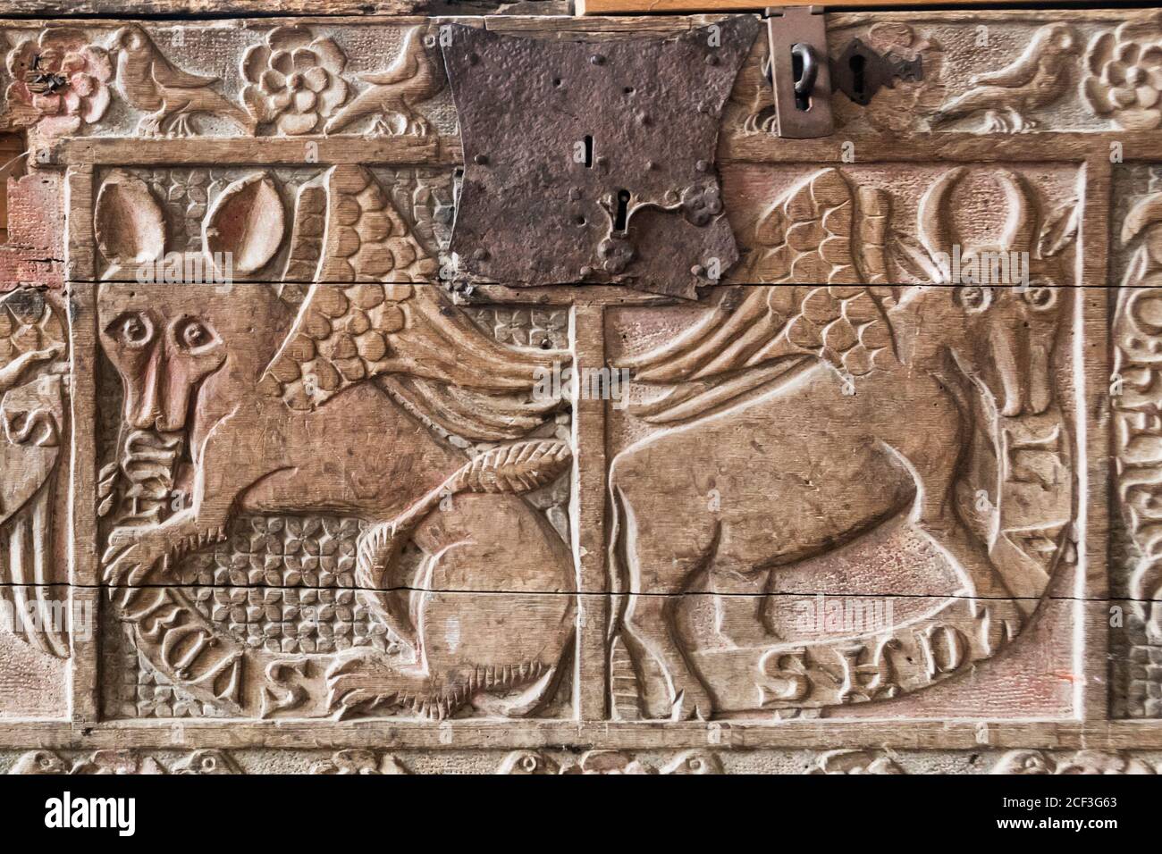 C14. Geschnitzte Holzkiste in Dersingham St. Nicholas Kirche Norfolk zeigt Symbole der Evangelisten St. Mark und St. Luke. Stockfoto