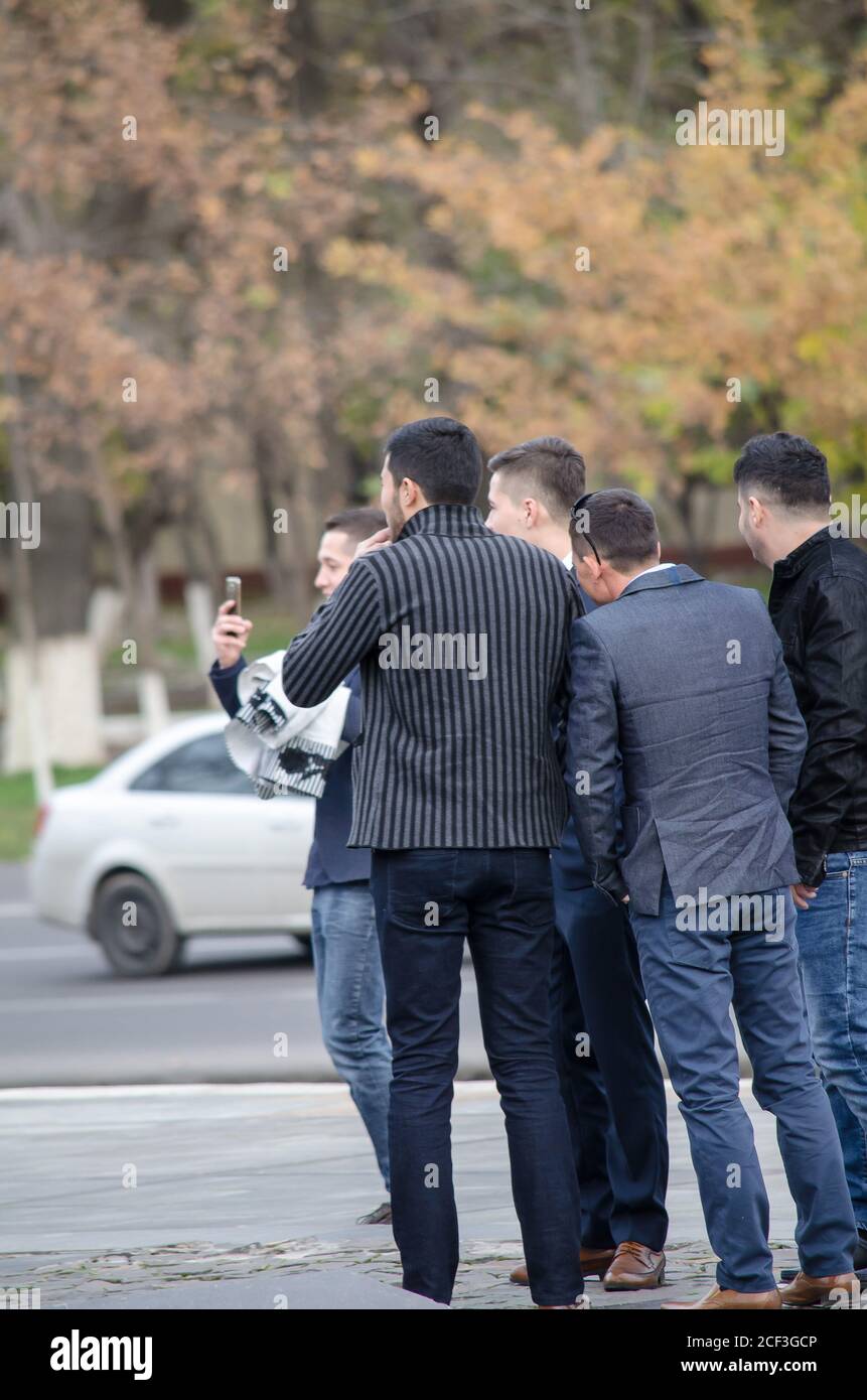 Gruppe von Jungs auf der Straße mit dem Rücken gedreht Guy guy ein Video auf einem Handy aufnehmen Stockfoto