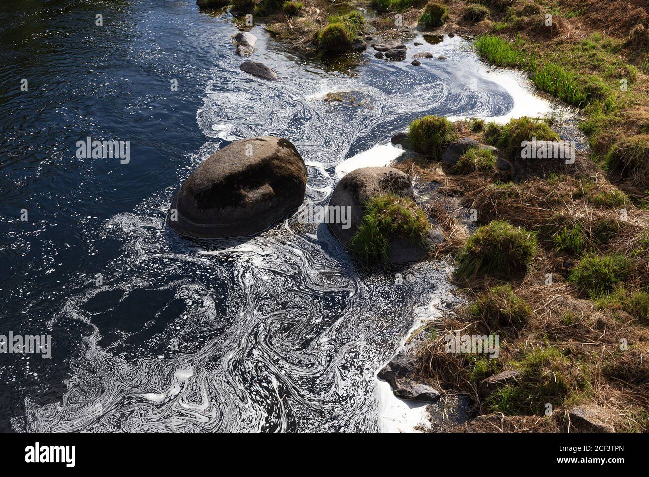Szene eines Flussufers mit verschmutztem Wasser durch Waschmittel oder Seife. Umweltschäden Stockfoto