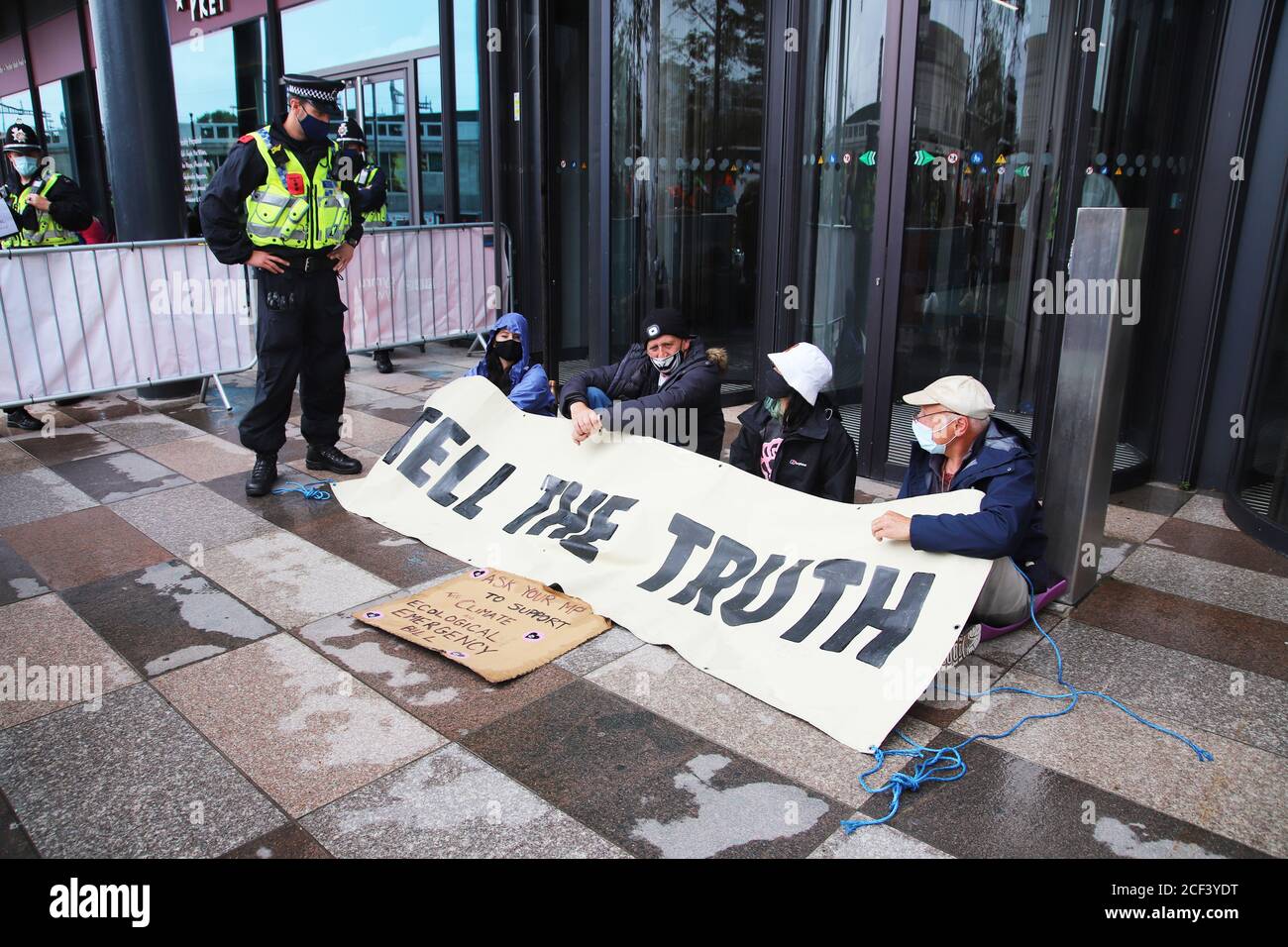 Cardiff, Wales, Großbritannien. September 2020. Extinction Rebellion Protestierende vor der BBC am dritten Aktionstag in Cardiff, 3. September 2020 im Rahmen des Herbstaufstandes. Demonstranten drängen die BBC, die Wahrheit über den Klimawandel zu sagen. Demonstranten sitzen vor der BBC in Cardiff und blockieren den Haupteingang mit einem Banner, das sagt, die Wahrheit zu sagen, flankiert von der Polizei Kredit: Denise Laura Baker/Alamy Live News Kredit: Denise Laura Baker/Alamy Live News Stockfoto