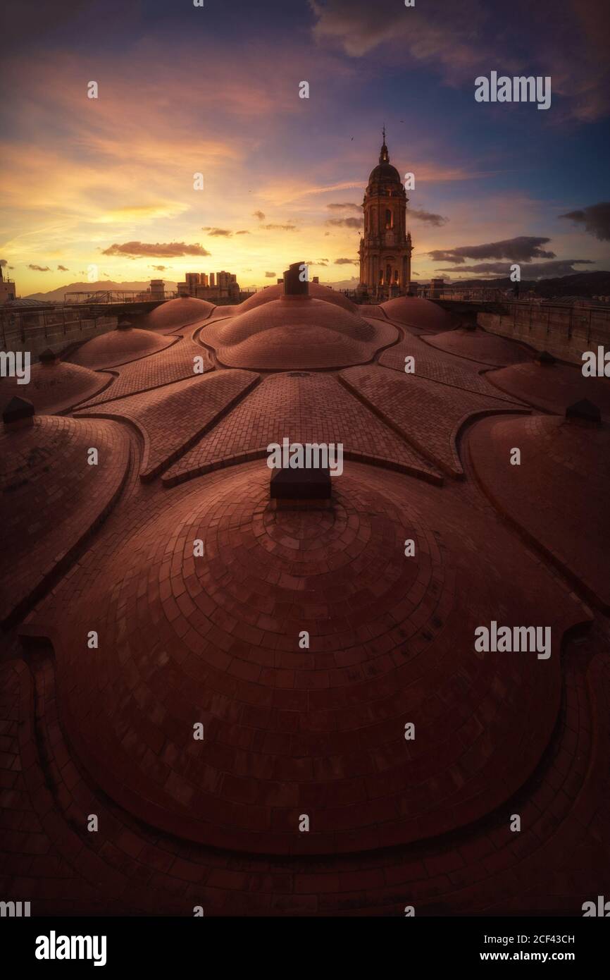 Unglaubliche Aussicht von der Dachterrasse auf die alte herrliche Kathedrale von Malaga Vor dem Hintergrund des farbenfrohen Sonnenuntergangs wolkiger Himmel im warmen Sommer Tag in Spanien Stockfoto