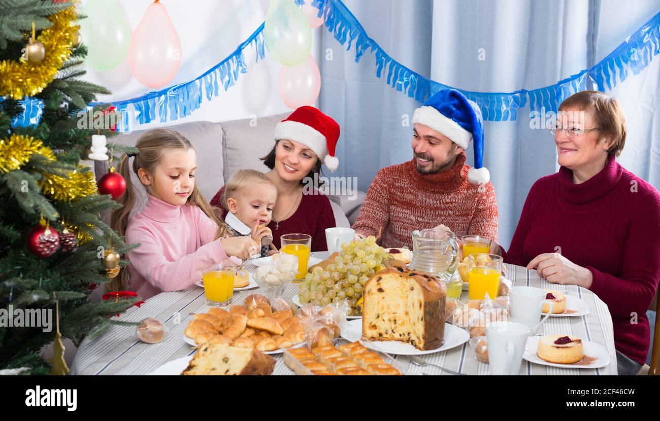 Großeltern 60-70 Jahre alt mit Kindern sprechen mit jedem Andere während des Weihnachtsdinners Stockfoto