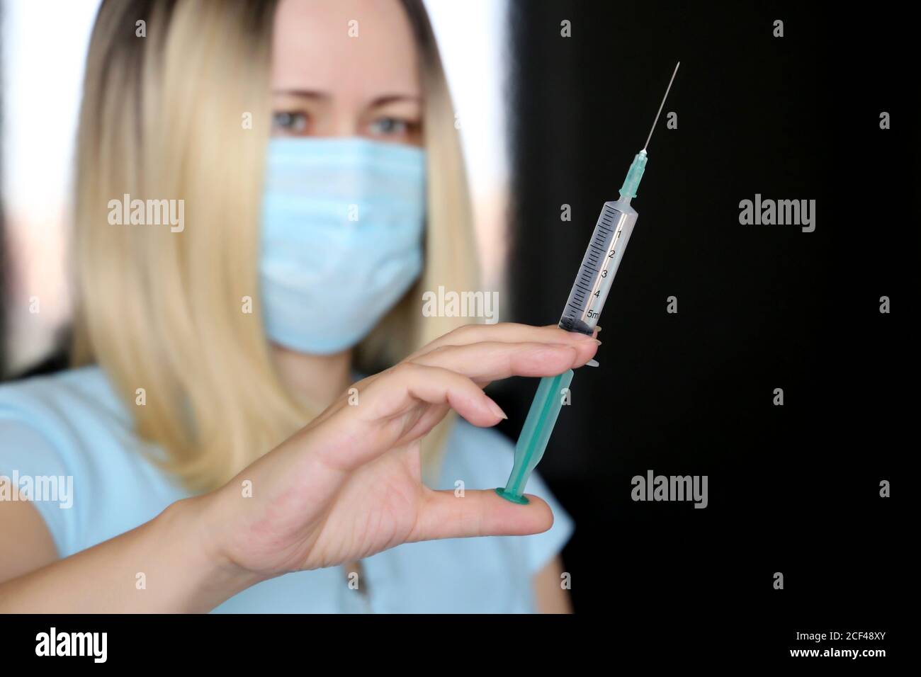 Frau mit Spritze, Arzt in medizinische Maske Vorbereitung auf die Injektion. Konzept der Impfung während der Covid-19-Pandemie Stockfoto