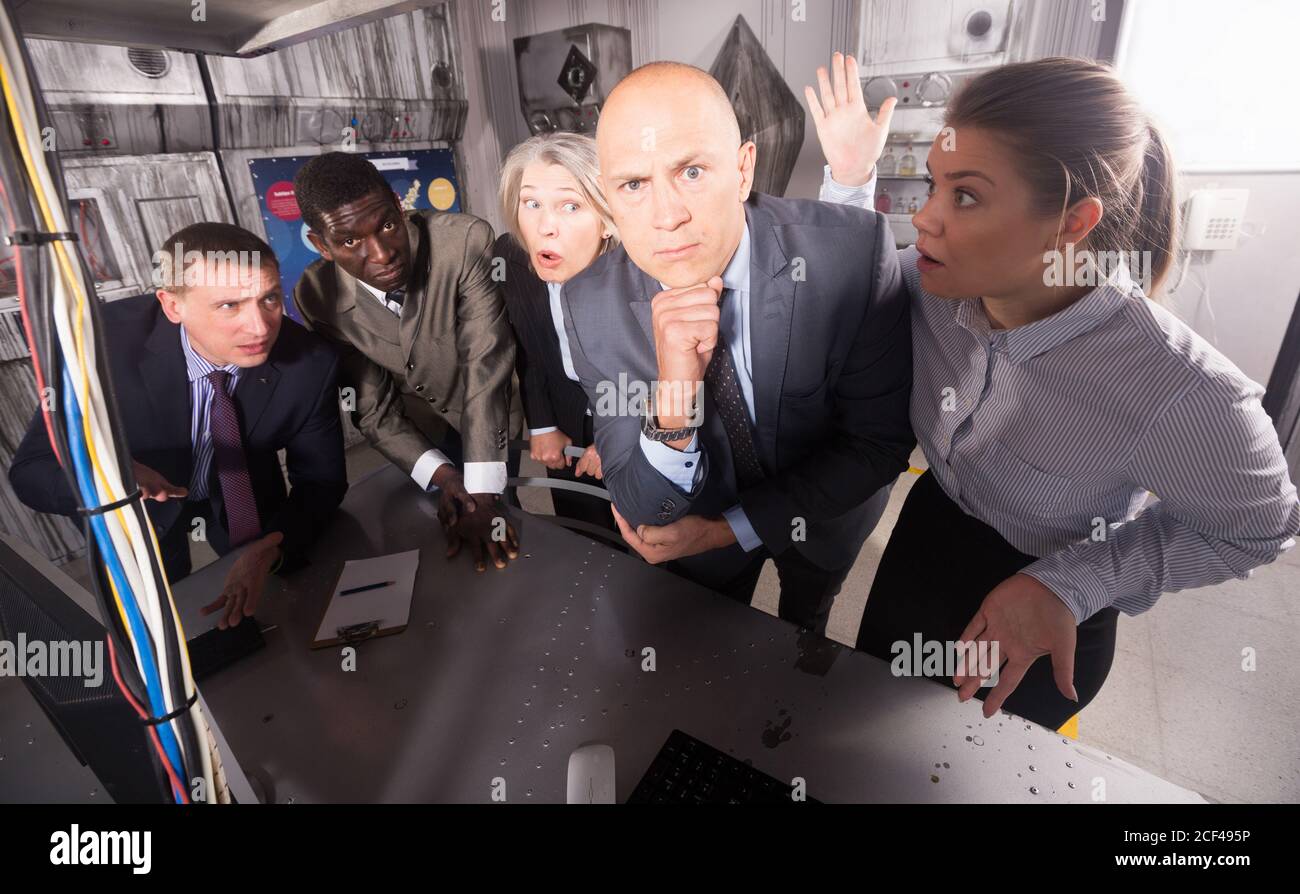 Schockierte Geschäftsleute, die darüber nachdenken, das Rätsel in geschlossenen Räumen des verlorenen Raum-Labors zu lösen. Konzept der Suche nach Lösungen in einer verworrenen Situation Stockfoto