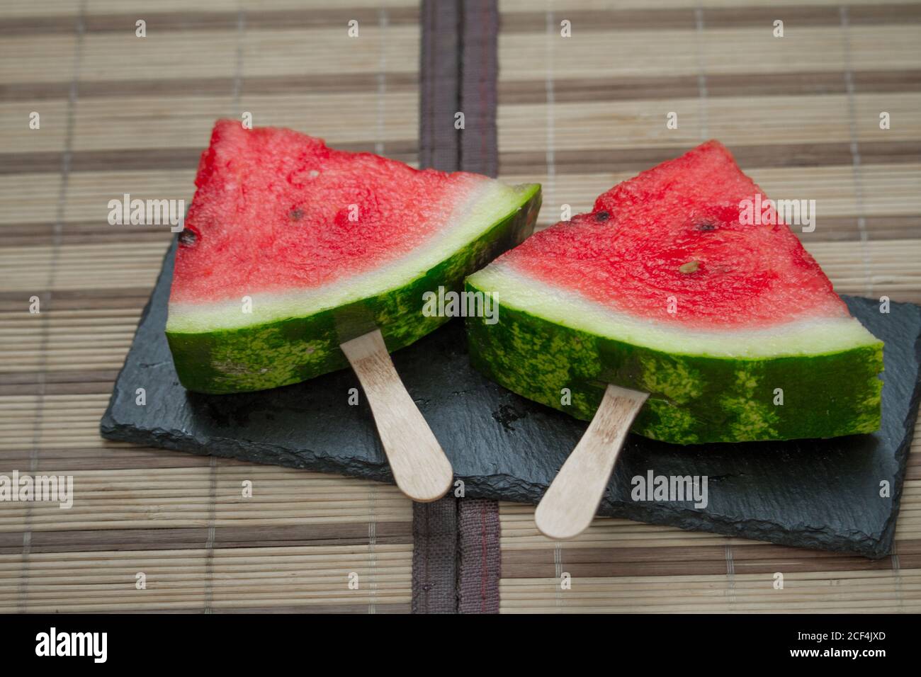 Wassermelonenscheibe auf schwarzer Steinplatte, Eiscreme-Konzept, selektiver Fokus Stockfoto