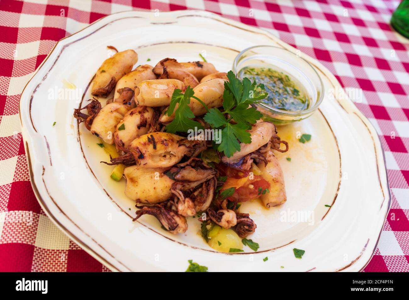Leckere gegrillte Tintenfische mit Gemüse auf dem Teller Stockfoto