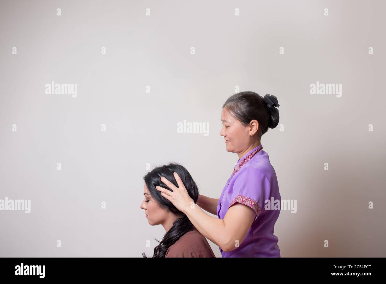 Asiatische Masseur tun thai Kopf massage für kaukasische Frau in Spa-Salon Stockfoto