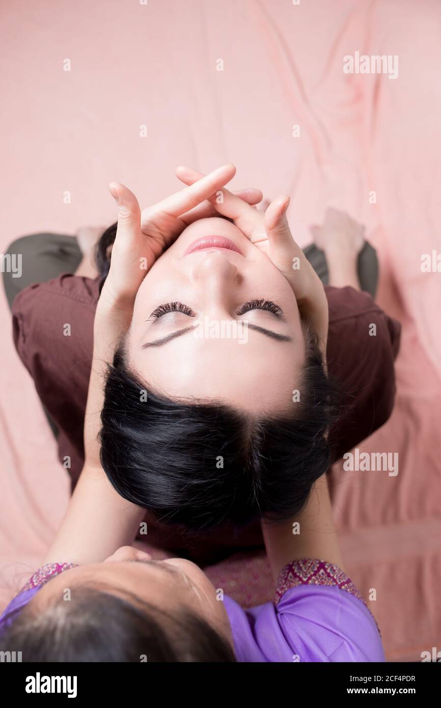 Asiatische Masseur tun thai Kopf massage für kaukasische Frau in Spa-Salon Stockfoto