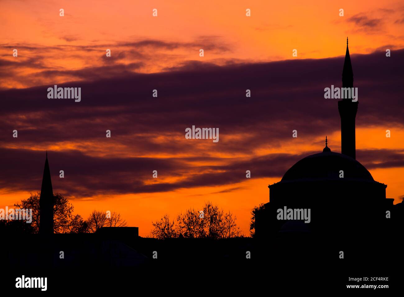 Silhouette der traditionellen Moschee mit Minarett gegen lebendige orange Himmel Am bewölkten Abend in der Türkei Stockfoto