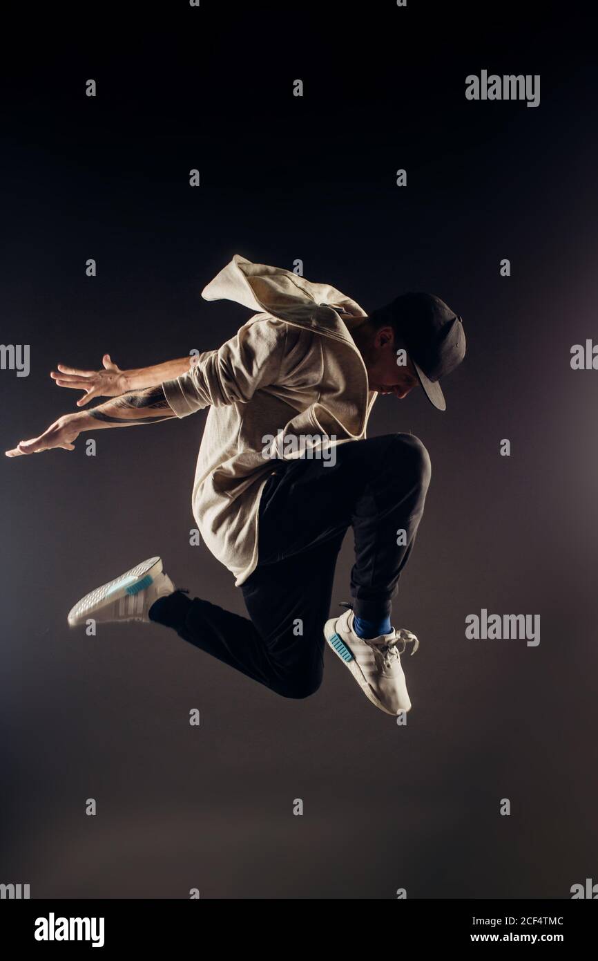 Springende junge männliche Tänzerin auf grauem Hintergrund Stockfoto
