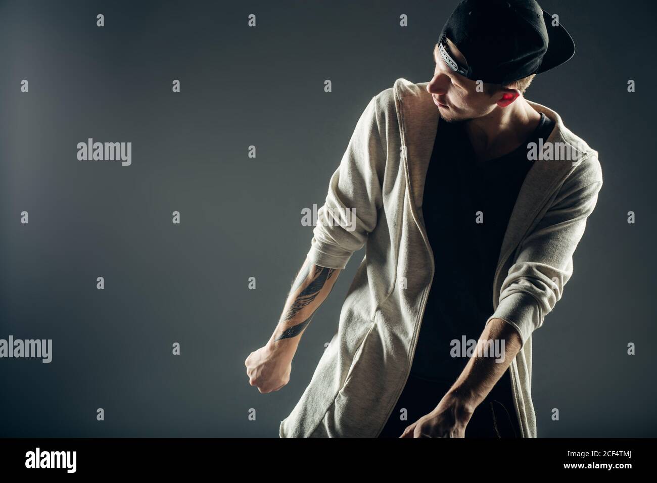 Jung und stilvolle moderne Tänzerin auf grauem Hintergrund Stockfoto