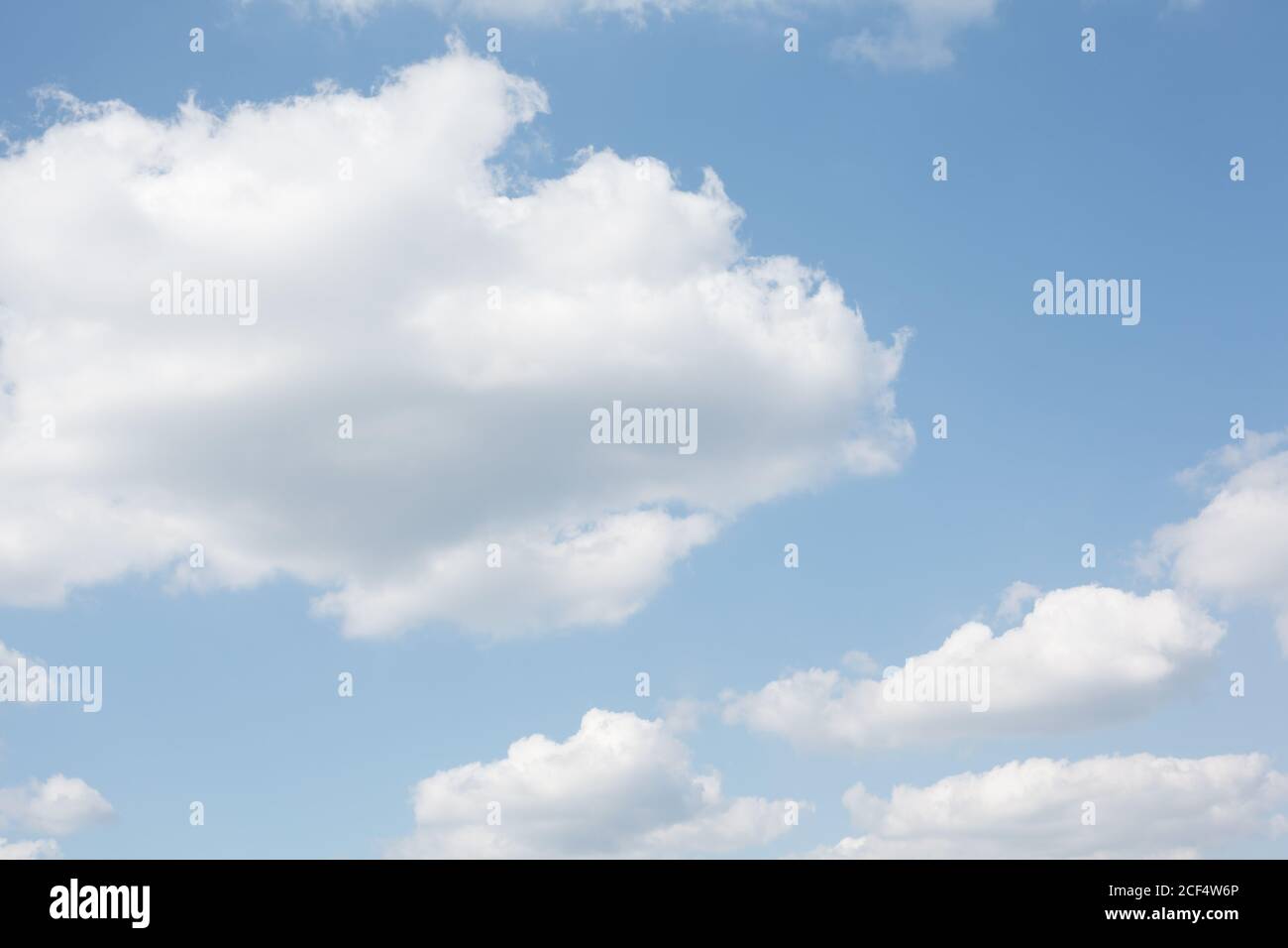 Pastellweiße flauschige Wolken auf babyblauen Himmel, natürlicher abstrakter Hintergrund Stockfoto