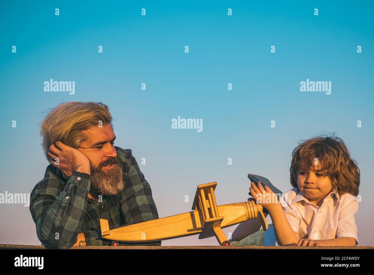 Vater und Sohn spielen mit Holzflugzeug. Stockfoto