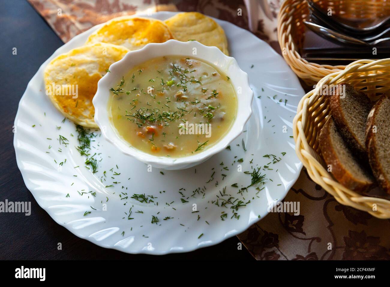 Typisch belarussisches Gericht Machanka, Sauce mit geschmortem Fleisch, Gemüse, Pilzen und saurer Sahne, serviert mit Pfannkuchen Stockfoto