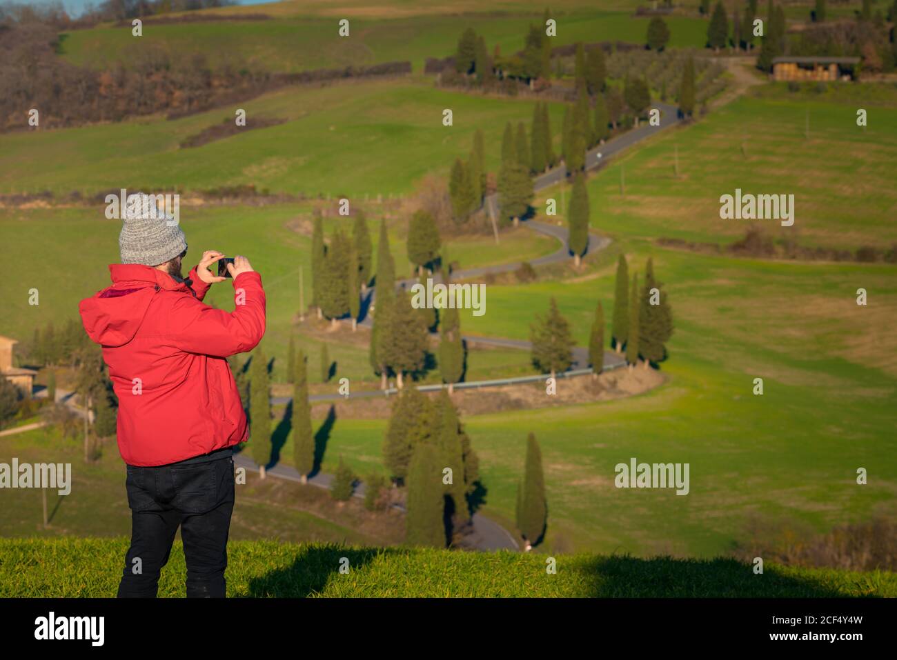 Rückansicht des Reisenden Mannes, der schöne grüne Landschaft in der Toskana, Italien fotografiert Stockfoto