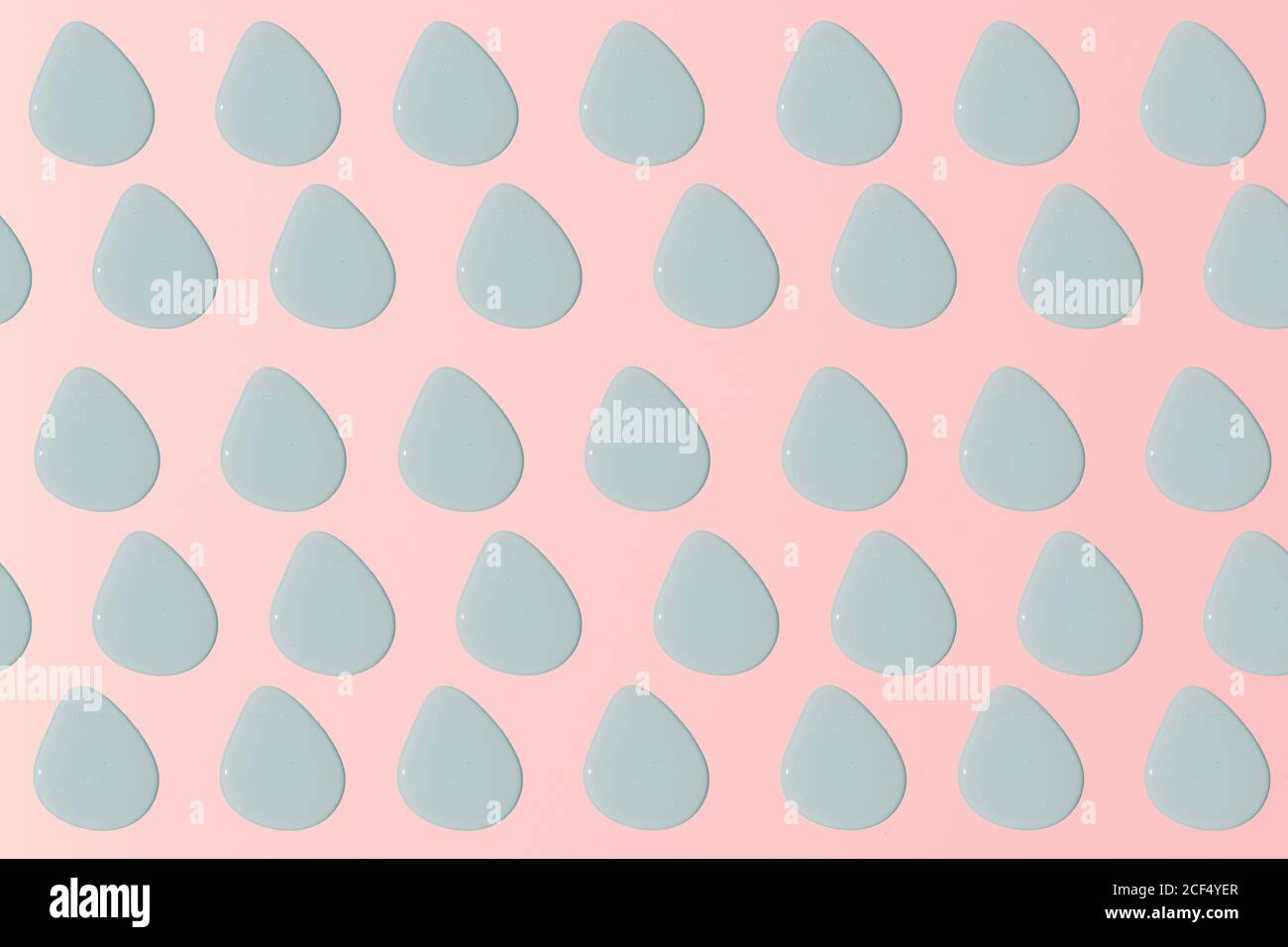 Draufsicht auf identische blassblaue Wassertröpfchen kippen zu Eine Seite symmetrisch auf rosa Hintergrund platziert Stockfoto
