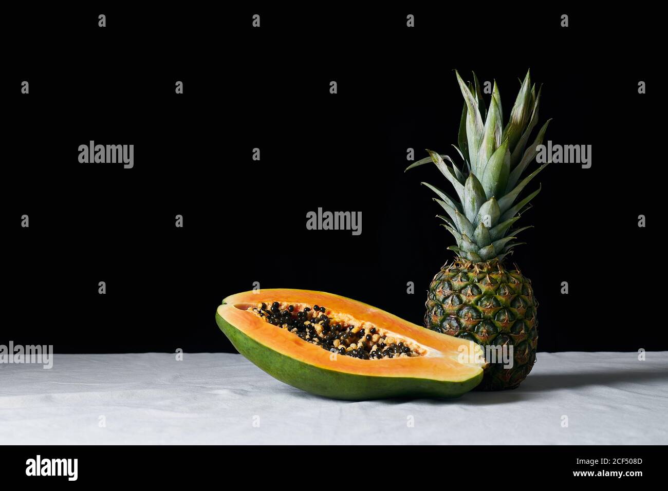 Stillleben mit Ananas und geschnittener Papaya Stockfoto