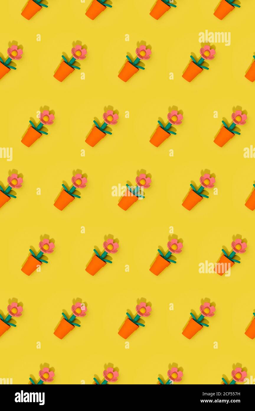 Nahtloses Osterfrühlingsmuster mit Blumen in roten Töpfen angeordnet In Reihen auf gelbem Hintergrund Stockfoto